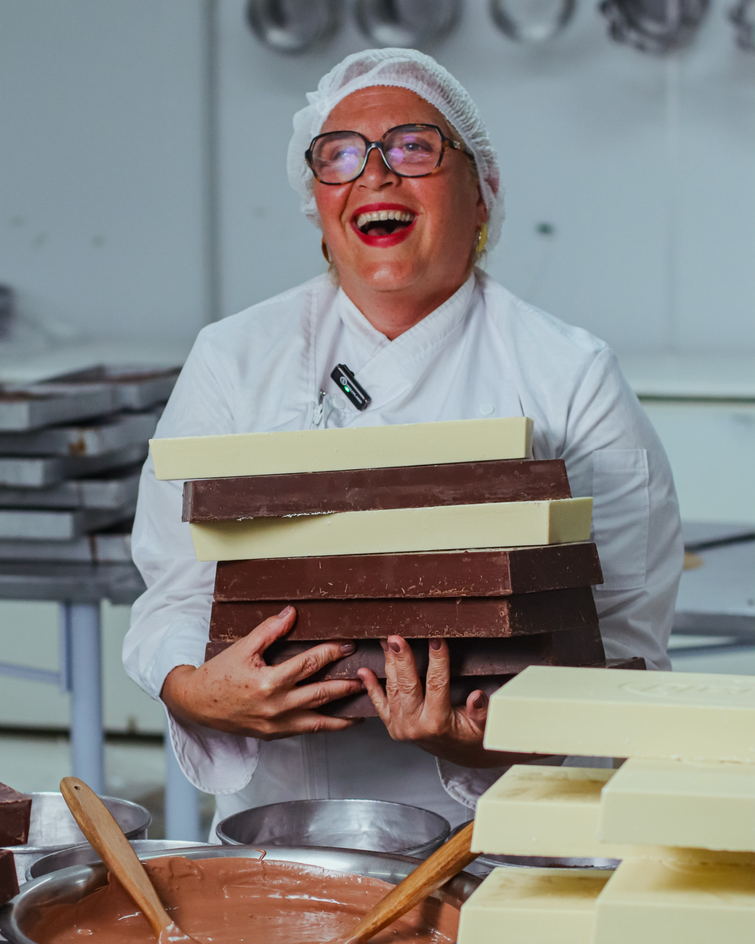 Confeiteira sorrindo com barras de chocolate