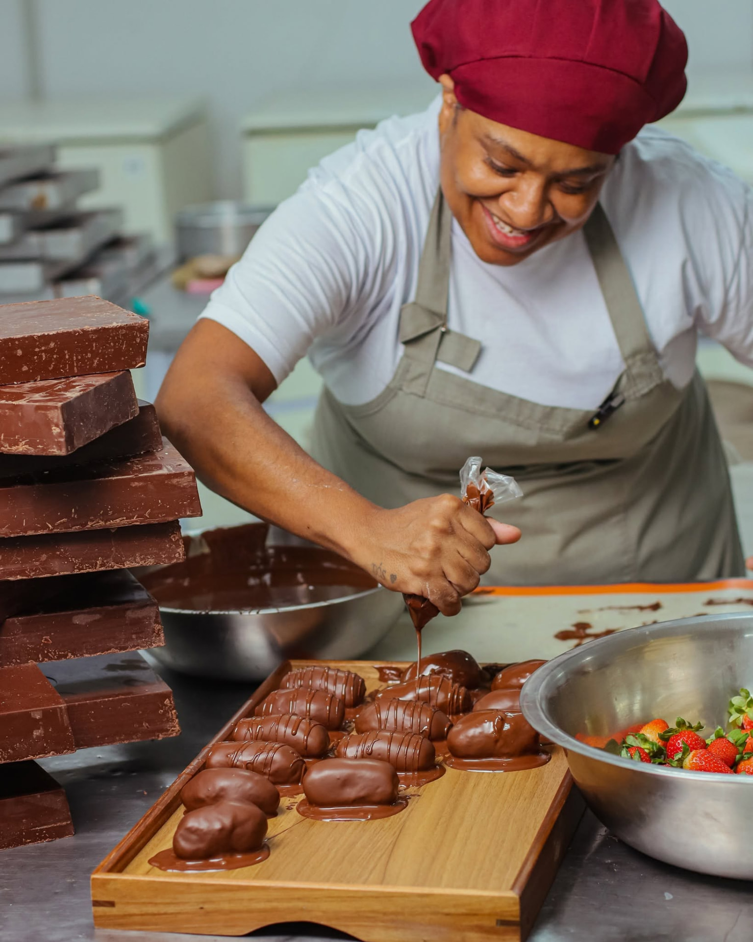 Confeiteira banhando bombons em chocolate